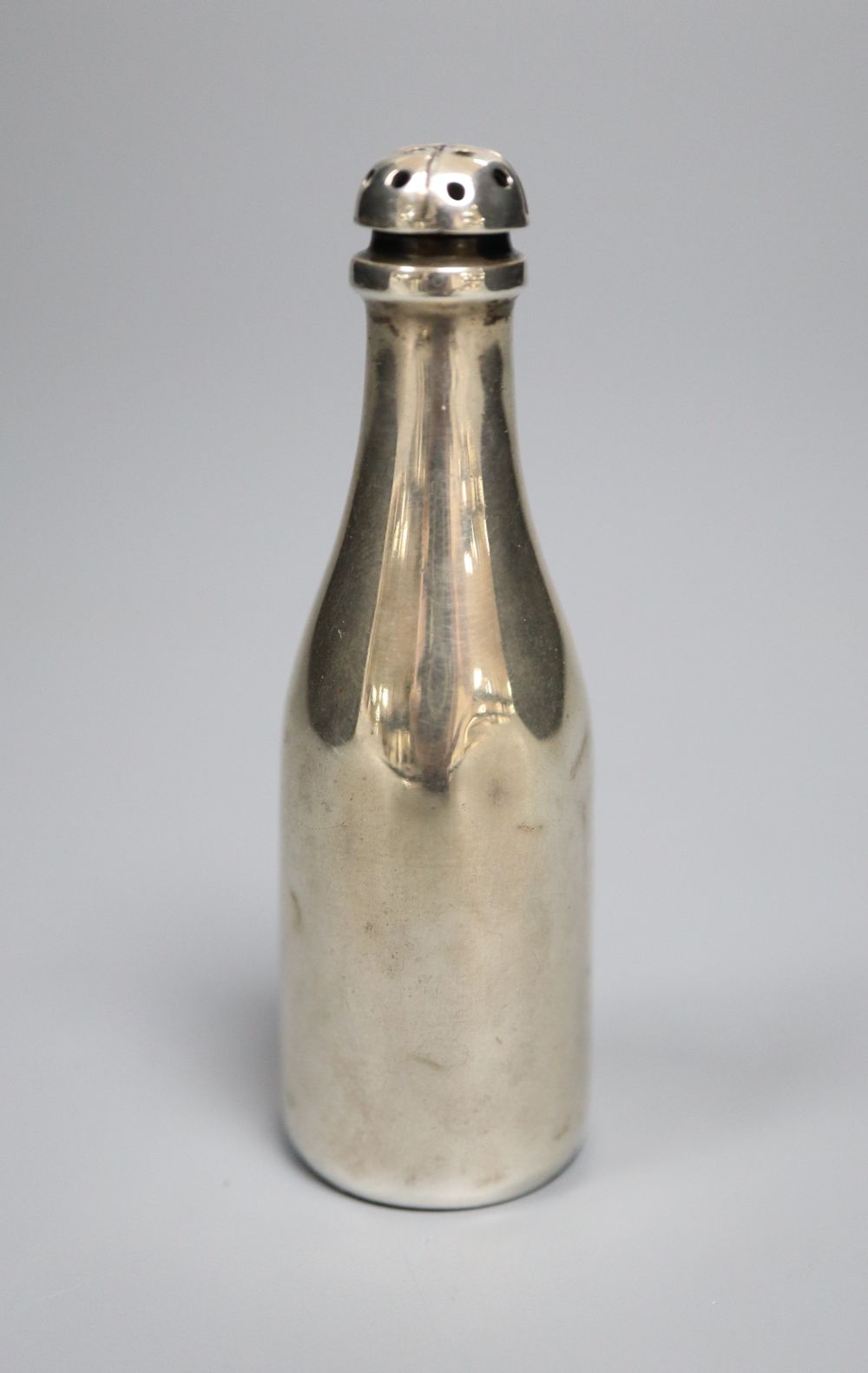 An Edwardian novelty silver pepperette, modelled as a Champagne bottle, Saunders & Shepherd, Birmingham, 1905,